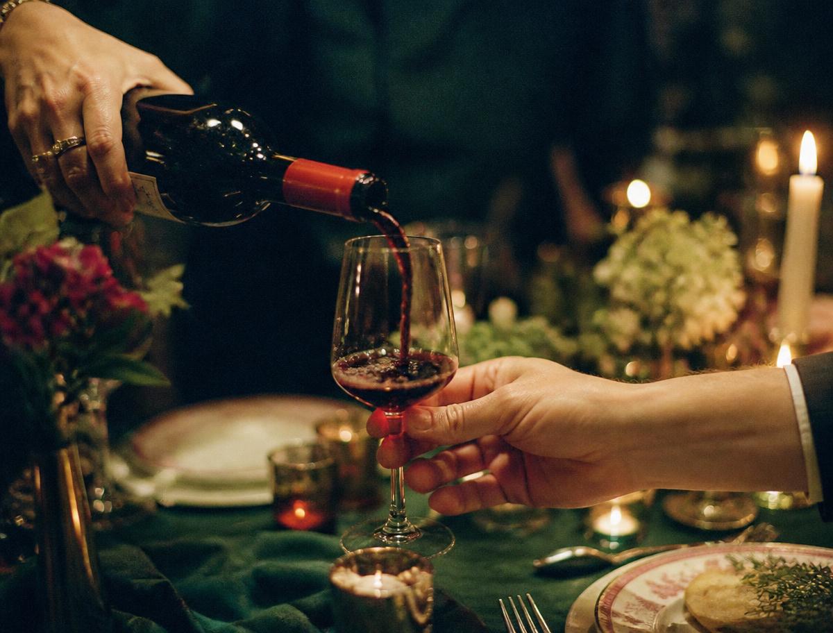 Wine being poured at a candlelit dinner table