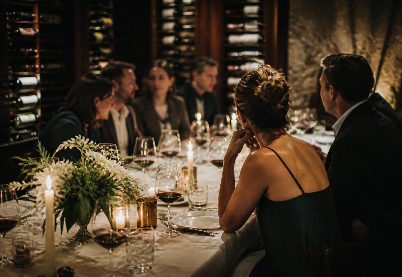 Guests in conversation around a candlelit table